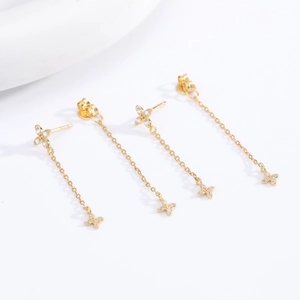 Detailed close-up of golden tassel flower earrings with zircon and fine chain fringe