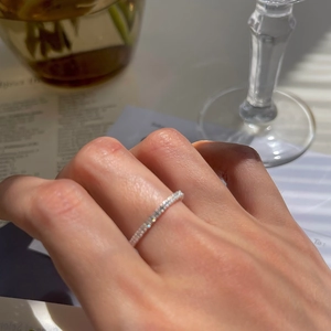 Detail of adjustable silver soft chain ring with zircon stones on female hand