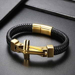 Detail of black braided leather men's bracelet with gold magnetic clasp and metal buckle