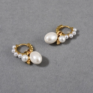Detailed macro view of vintage gold hoop earrings with detachable oval and gradient pearls