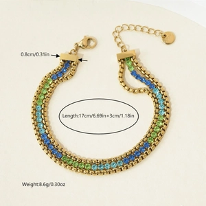 Macro detail of triple-layer stainless steel bracelet with green and blue crystal accents