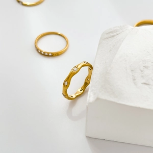 Minimalist gold wave ring with zircon inlay and thin eternity bands on stone