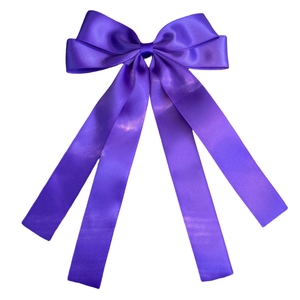 Detail of a purple satin double-layer bow hair clip with flowing ribbons on white background