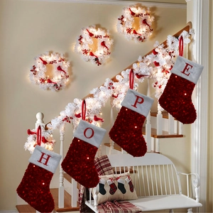 Christmas stockings featuring HOPE lettering hanging on a festive decorated stair railing