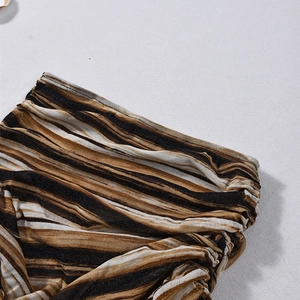 Gros plan sur la texture rayée scintillante et les coutures de cet ensemble deux pièces