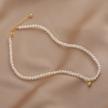 Dettaglio collana di perle d'acqua dolce con chiusura a moschettone dorata e catenella
