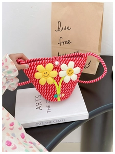 Nahaufnahme einer Strohtasche mit 3D-Blumen mit Smileys und Perlenknopf-Verzierungen
