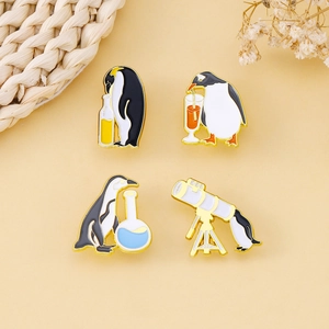 Set of four creative penguin enamel pins featuring telescope and bottle designs