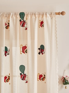 Detail showing Santa Claus embroidery on semi-sheer white lace Christmas curtains