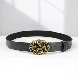 Detail of vintage bohemian leather belt with floral embossing and bronze bee buckle