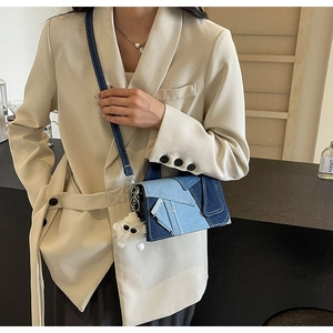 Détail du sac à bandoulière en denim patchwork avec un joli monstre en peluche blanc