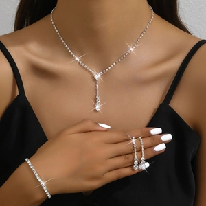 Close-up of sparkling rhinestone necklace and earrings set worn by a female model