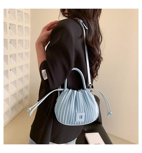 Close-up of light blue pleated bucket bag with square buckle and round handle
