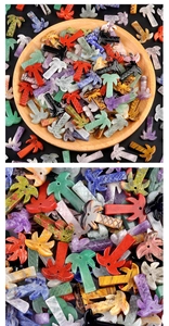 Macro view of assorted natural crystal coconut tree pendants in a wooden bowl for DIY jewelry