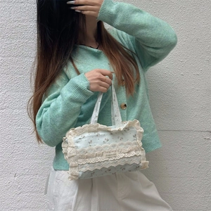 Détail du sac cabas en toile fleurie avec bordure en dentelle blanche et motifs bleus