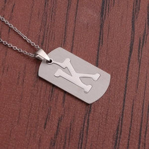 Détail d'un pendentif rectangulaire en acier argenté avec lettre K ajourée gravée