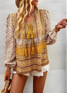 Detail of bohemian V-neck blouse featuring paisley print and tassel drawstrings