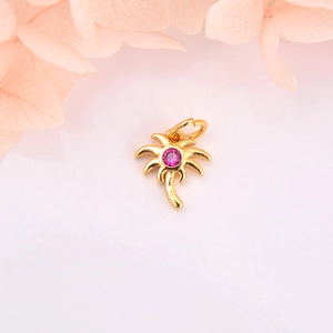 Macro detail of golden palm tree pendant with pink zircon for DIY jewelry crafts