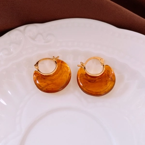 Detailed macro of vintage resin hoop earrings in amber tortoiseshell with 18k gold accents