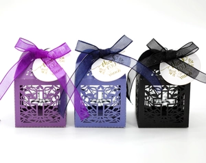 Opengewerkte lasergesneden geschenkdozen in paars, blauw en zwart met linten