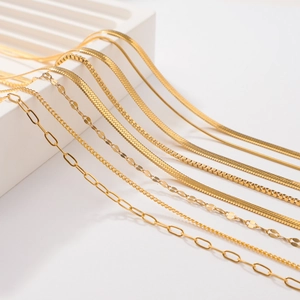 Macro view of various gold-plated stainless steel chains including snake and box link styles