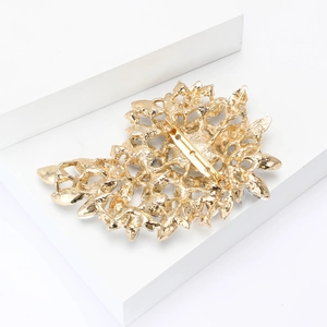Detail view of the golden alloy floral brooch back with a secure safety pin closure