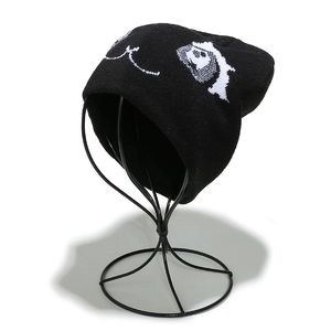 Gros plan du bonnet en maille noir avec broderie d'yeux de dessin animé sur support