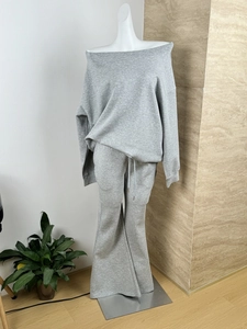 Detail view of the gray off-shoulder sweatshirt and wide-leg trousers set on a mannequin