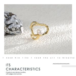 Close-up of gold irregular geometric ring featuring a white pearl on a stone base