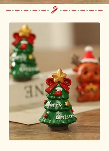 Close-up of resin mini Christmas tree with red bow and Merry Christmas lettering