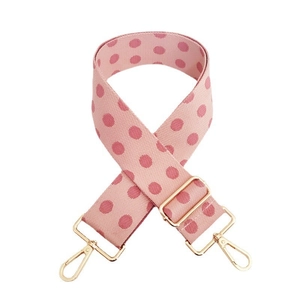 Close-up of pink polka dot bag strap with adjustable gold buckle and metal hooks