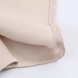 Macro detail of high-quality champagne satin fabric with smooth stitching on the hemline