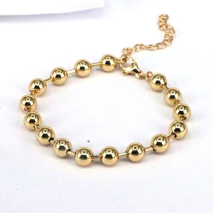 Detail of golden beaded bracelet featuring a lobster clasp and adjustable extension chain