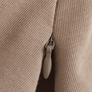 Close-up of invisible zipper detail on khaki ribbed knit sweater for women