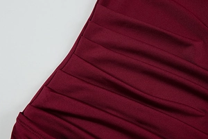 Close-up of deep red pleated fabric texture and high-quality stitching on summer dress