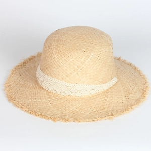 Detail showing the white lace ribbon and frayed edges of the woven raffia sun hat