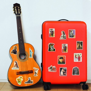 Famous oil painting art stickers applied to an orange guitar and red luggage suitcase