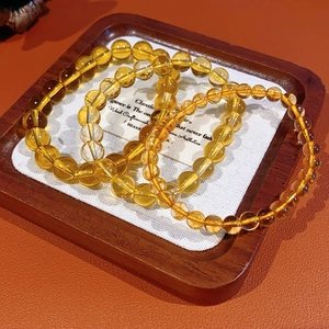 Macro detail of high-transparency yellow citrine beads with natural ice cracks on tray