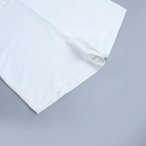 Detailed view of white athletic bodysuit fabric showing clean seams and fine texture