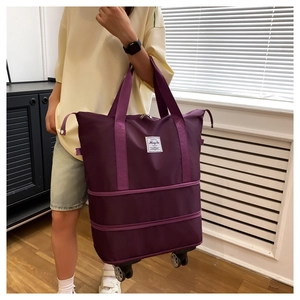 Detail view of large purple travel bag with wheels and expandable bottom layer