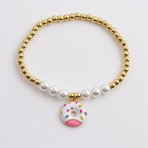 Golden beads and white pearls bracelet with a cute pink and white donut charm pendant