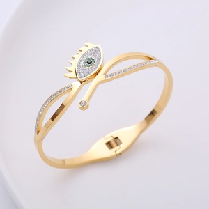 Polished gold Evil Eye open spring bracelet with blue and white crystal accents