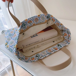 Détail du sac cabas en coton fleuri avec poignées en cuir et poche intérieure zippée