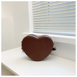 Dettaglio di una borsa a tracolla marrone a forma di cuore in pelle PU con ganci in metallo
