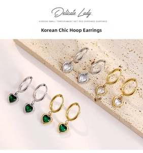 Gros plan de boucles d'oreilles cœur en zircon or et argent sur dalle de pierre