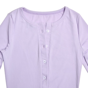 Dettaglio della tutina in maglia a coste viola con scollo rotondo e patta a quattro bottoni