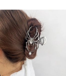 Detail of silver spider hair claw clip with large crystal and pearl on model's hair