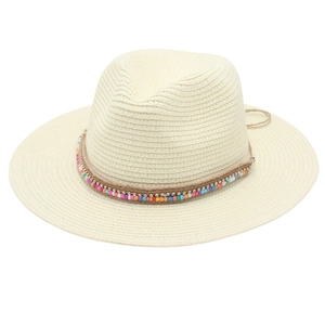 Close-up of colorful beaded band on cream straw fedora hat with woven texture details
