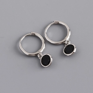 Macro detail of S925 sterling silver hoop earrings with circular black zircon pendant charms