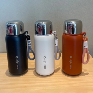 Three portable matte vacuum flasks in black, white, and orange with steel mirror caps